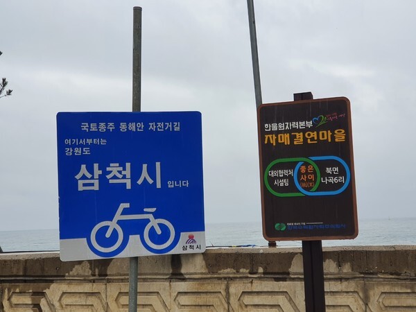 고포마을에 있는 동네알림판. 오른쪽 알림판에는 “(경상북도 울진군) 북면 나곡6리”라고 표시되어 있고, 왼쪽 알림판에는 “강원도 삼척시”라고 표시되어 있다. 조그마한 동네가 경상북도와 강원도로 나뉘어 있는 것이 이채롭다.