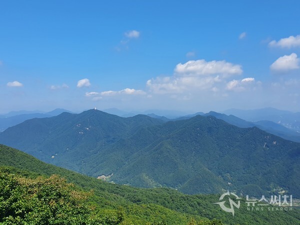 검단산 정상에서 바라본 예봉산과 운길산. 검단산 정상에서는 북쪽방향으로 한강 건너 남양주시 와부읍 팔당리에 있는 ‘예봉산’과 남양주시 조안면에 있는 ‘운길산’이 한눈에 조망된다. 파아란 가을하늘에 뭉게구름이 피어 있고 그 밑에 짙은 녹색의 숲으로 이루어진 산세가 연이어 펼쳐져 있어 장관을 이룬다.