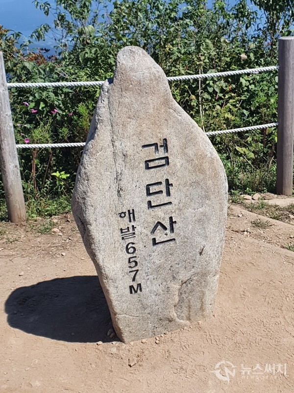 검단산 정상 표지석. 검단산 정상은 해발 657m 높이이다. 검단산 정상에서는 북동쪽으로 남한강과 북한강 물이 합류하는 두물머리(양수리)와 팔당댐이 뚜렷하게 보이고 한강 건너 예봉산 뿐만 아니라 예봉산 정상에 있는 둥근 공 모양의 강우레이더도 한눈에 조망된다.