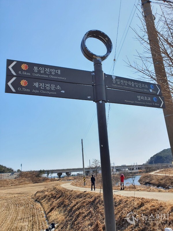 명파리 시골길. 해파랑길 50코스 중 제진검문소에서 남쪽방향으로 도보길을 걷다보면 명파초교와 명파해수욕장으로 나뉘는 갈림길이 나오며 조그만 하천 천변 뚝방길 옆에 낡은 해파랑길 이정표가 서 있다.